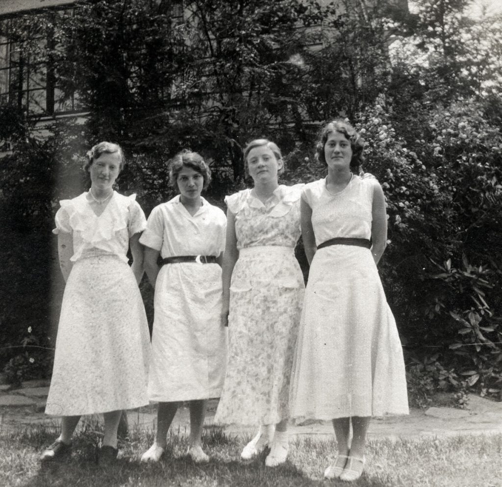 Four young women in dresses, including Polly Turner.